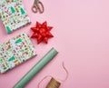 Rolls with wrapping paper, brown rope, scissors, decor and a wrapped square box with a gift Royalty Free Stock Photo