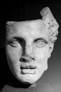 Black and white photo showing in close-up the broken head of ancient roman statue portraiting a young man Royalty Free Stock Photo