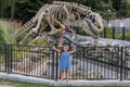 ROMA, ITALY - JULY 2019: Little charming girl child near the skeleton of a huge dinosaur in an amusement park Royalty Free Stock Photo