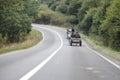 Roma people drive a horse drawn cart on a public road