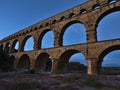 Roman aqueduct Pont du Gard with stone arches crossing Gardon river in the evening near Vers-Pont-du-Gard, Occitanie, France. Royalty Free Stock Photo