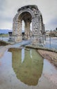 Roman Arch of Caparra reflected on puddle, Caceres, Spain Royalty Free Stock Photo