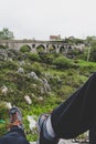 Roman bridge or old bridge. Stone bridge, part of a Roman road. Dry river. montenegro village. male legs in hiking boots