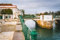 The Roman bridge with white railings and stone arches, crossing over a calm river. Tavira, Portugal Royalty Free Stock Photo