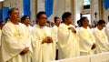 Roman Catholic priests stand as they listen to homily during congregation mass