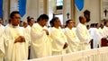 Roman Catholic priests stand as they listen to homily during congregation mass