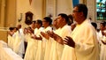 Roman Catholic priests stand as they listen to homily during congregation mass