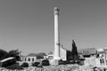 Roman column with mediterranian houses and stone brickwork black and white