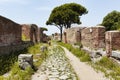 Roman empire village street view and its architecture in archeological excavation of Ostia Antica with cobblestone pathway and Royalty Free Stock Photo