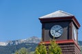 Roman Numeral Clock Tower with rocky mountains and blue sky in the background Royalty Free Stock Photo