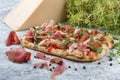 Roman pizza. Sorrentino Pinza with prosciutto, capers and arugula