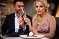 Romance and dating concept. Young couple man and woman with champagne glasses celebrating and toasting in restaurant Royalty Free Stock Photo