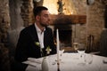 Romance and dating concept. Young man with champagne glass on a table waiting for woman to celebrate in restaurant Royalty Free Stock Photo