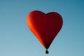 The romance of flying in a balloon in the shape of a red heart.