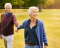 Romance, retirement and old couple holding hands in field, walking in nature and happy smile on grass. Peace, senior man Royalty Free Stock Photo