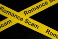 Romance scam alert, caution and warning concept. Yellow barricade tape with word in dark black background. Royalty Free Stock Photo