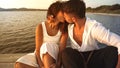 Romance scene of heterosexual mixed race couple of lovers kissing with passion on a wooden pier at sunset - Romantic handsome