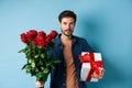 Romance and valentines day. Man presenting bouquet of red roses to lover. Boyfriend bring flowers and gift on romantic