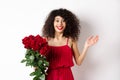 Romance and Valentines day. Woman gasping surprised and happy, receive surprise gift from lover, holding bouquet of red Royalty Free Stock Photo