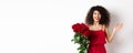 Romance and Valentines day. Woman gasping surprised and happy, receive surprise gift from lover, holding bouquet of red Royalty Free Stock Photo