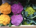 Romanesco broccoli and purple and orange cauliflower in a grocery. Variety of colorful vegetables in wooden boxes Royalty Free Stock Photo