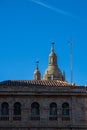 Romanesque domes of the old cathedral of Salamanca behind the facade and roof of a classical and monumental building. Royalty Free Stock Photo