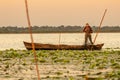 ROMANIA, DANUBE DELTA, AUGUST 2019: Fisherman checking the nets at sunrise in an old traditional fishing boat Royalty Free Stock Photo