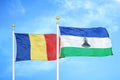 Romania and Lesotho two flags on flagpoles and blue sky