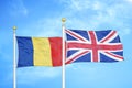 Romania and United Kingdom two flags on flagpoles and blue sky