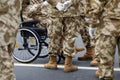 Romanian army veteran soldiers, of which one is injured and disabled, sitting in a wheelchair