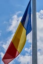 The romanian flag in the wind with blue sky with clouds Royalty Free Stock Photo