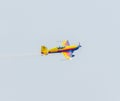 The Romanian Hawks Team pilot with his colored airplane training in the blue sky. Royalty Free Stock Photo