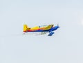 The Romanian Hawks Team pilot with his colored airplane training in the blue sky. Royalty Free Stock Photo