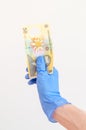 50 Romanian lei banknote in hand in surgical gloves.