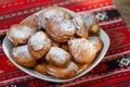 Romanian mini doughnuts on a plate on red traditional cloth