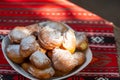 Romanian mini doughnuts on a plate on red traditional cloth