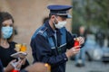 Romanian policeman with a surgical mask due to the covid-19 pandemic takes the Holy Light during the orthodox Easter