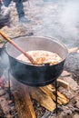 An unknown person prepares a traditional Romanian food prepared at the cauldron on the open fire Royalty Free Stock Photo