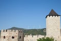 Romanian Wind Farm with Wind Turbine and windmills facing an old castle located on the Serbian side of the Danube river Royalty Free Stock Photo