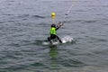 Wakeboarding with a guide mechanism. Unidentified little girl holding on to a rope, learning how to move on wakeboarding