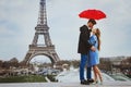 couple kissing under umbrella near Eiffel Tower, honeymoon in Paris Royalty Free Stock Photo