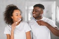 Romantic African American couple brushing teeth together in modern bathroom Royalty Free Stock Photo