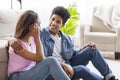 Cheerful african couple in love sitting on floor and chatting Royalty Free Stock Photo