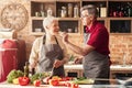 Romantic aged couple tasting food while cooking lunch in kitchen together Royalty Free Stock Photo