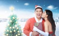 Romantic asian girl giving xmas gift and kissing her boyfriend Royalty Free Stock Photo