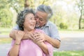 Romantic asian healthy senior couple looking each other eyes and relaxing in the park together. Royalty Free Stock Photo