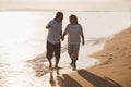 The romantic Asian senior couple hand in hand while walking on summer beach sunset. Travel leisure and activity after retirement Royalty Free Stock Photo