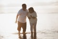 The romantic Asian senior couple hand in hand while walking on summer beach sunset. Travel leisure and activity after retirement Royalty Free Stock Photo