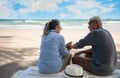 Romantic of Asian senior couple tourist is sitting hand in hand and talking on beach chair with hat in summer vacation Royalty Free Stock Photo