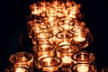 Romantic atmosphere, many small, lit candles on the table. Dark background Royalty Free Stock Photo